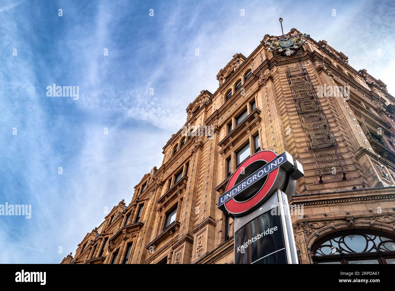 London, UK - 17 April 2022: The Knightsbridge underground sign, outside of the entrance to Harrods, on the Brompton Road, London. Spring day with blue Stock Photo