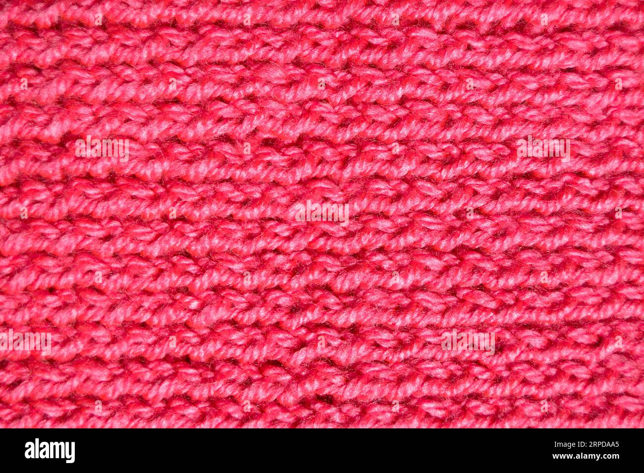 Pattern fabric made of wool. Handmade knitted fabric pink and red wool background texture Stock Photo