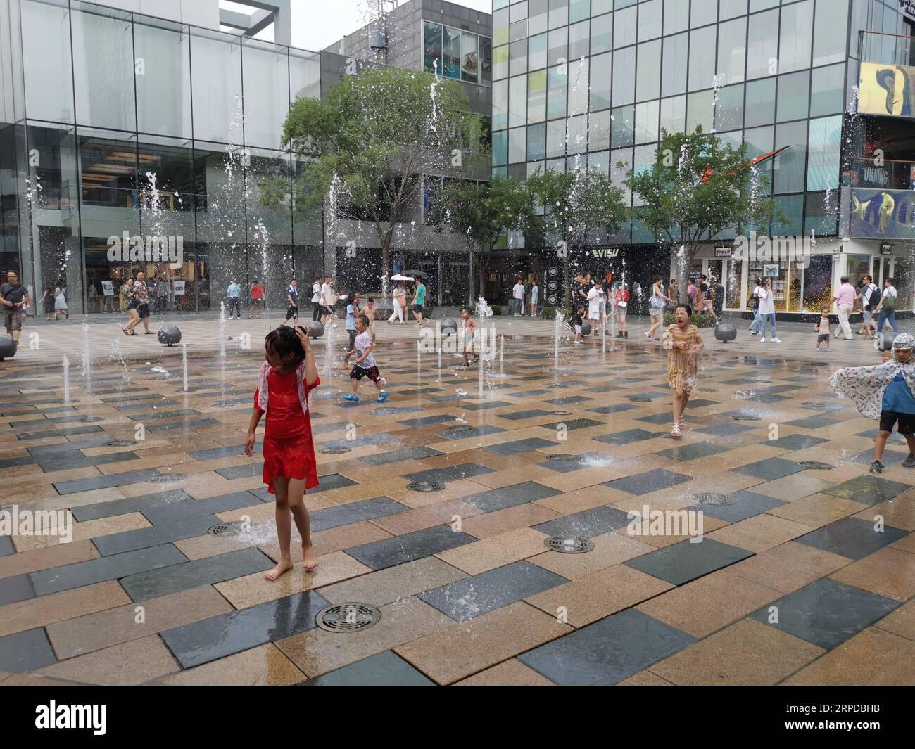 (190730) -- BEIJING, July 30, 2019 -- Photo taken with a mobile phone shows children playing with water at Sanlitun in Chaoyang District in Beijing, capital of China, July 28, 2019. ) (BeijingCandid)CHINA-BEIJING-SUMMER (CN) JuxHuanzong PUBLICATIONxNOTxINxCHN Stock Photo