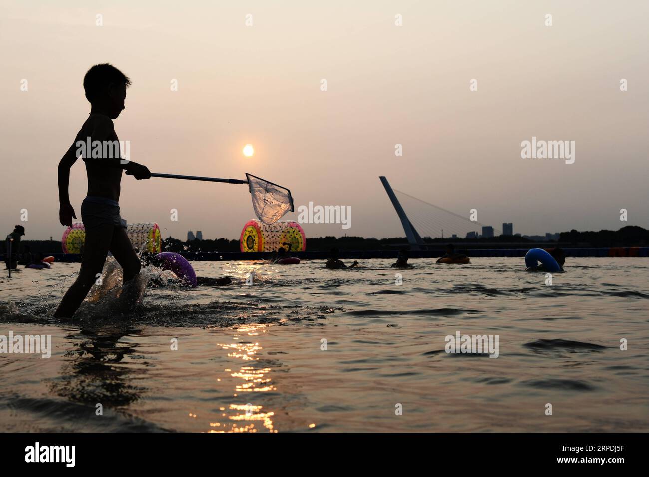 (190805) -- HARBIN, Aug. 5, 2019 -- A kid plays along the Songhua River in Harbin, capital of northeast China s Heilongjiang Province. Attracted by the coolness in summer, many tourists come to Harbin for vacation. Meanwhile, Harbin is a city of music for the locals who got in touch with European classical music in an earlier time in China. With the cool summer and rich culture, Harbin received 36.23 million tourists and made revenue of 60.7 billion yuan (8.6 billion U.S. dollars) in the summer of 2018. ) CHINA-HEILONGJIANG-HARBIN-SUMMER-TOURISM(CN) WangxJianwei PUBLICATIONxNOTxINxCHN Stock Photo
