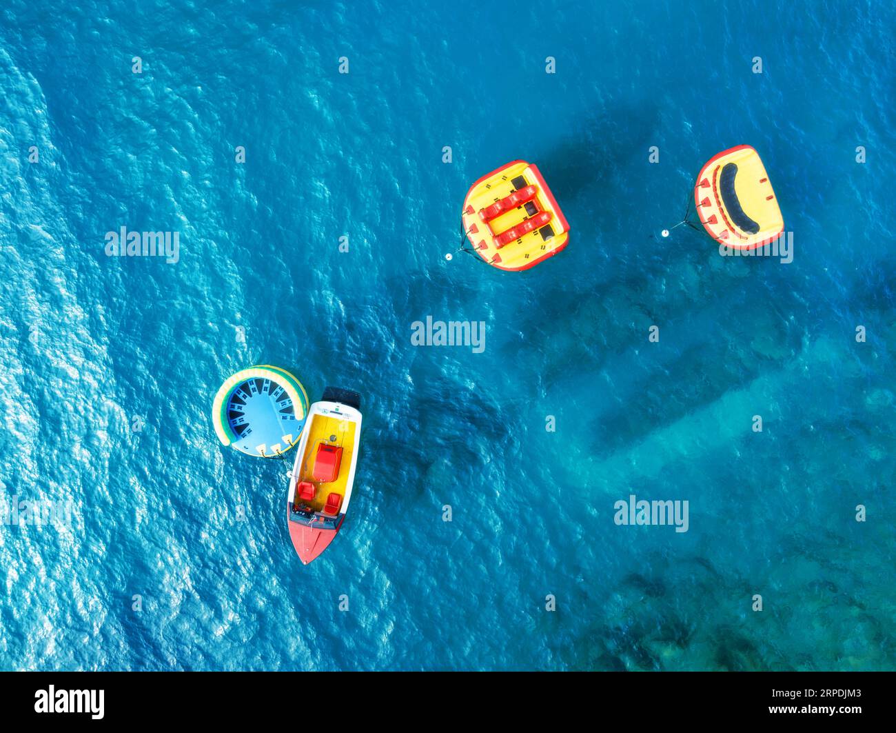 Aerial view of boat and inflatable rings on blue sea in summer Stock ...