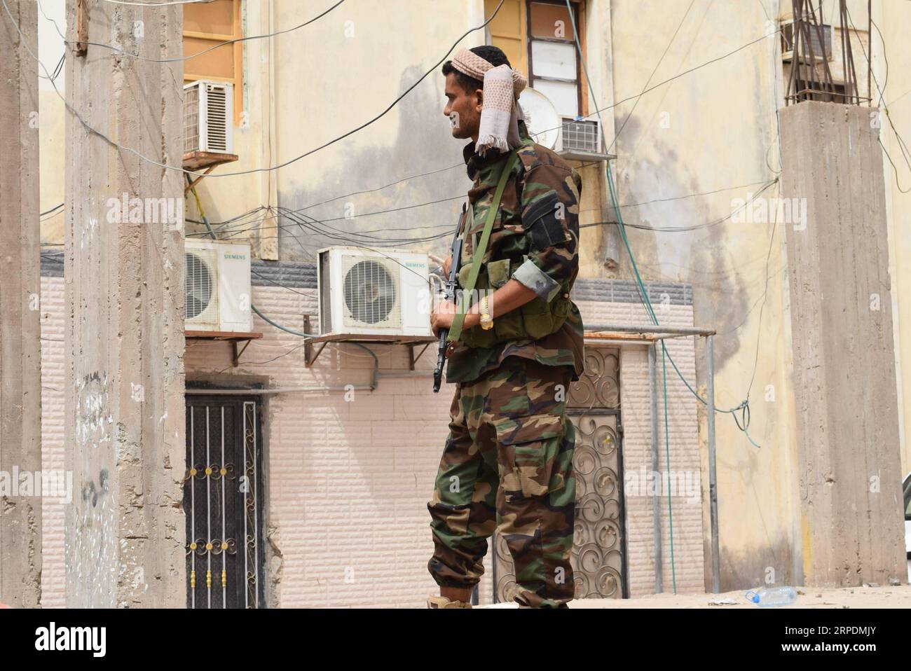 (190807) -- ADEN (YEMEN), Aug. 7, 2019 (Xinhua) -- A soldier loyal to the Southern Transitional Council (STC) guards the mourners at the area of the presidential palace in Aden, Yemen, on Aug. 7, 2019. At least two people were killed and 10 others injured in clashes between presidential guard forces and mourners in the southern port city of Aden on Wednesday, a medical official told Xinhua. (Photo by Murad Abdo/Xinhua) YEMEN-ADEN-CLASHES PUBLICATIONxNOTxINxCHN Stock Photo