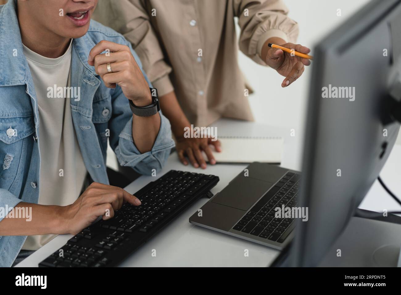 Two developer programmer discussing to checking code on monitor about programming to developing web. Stock Photo