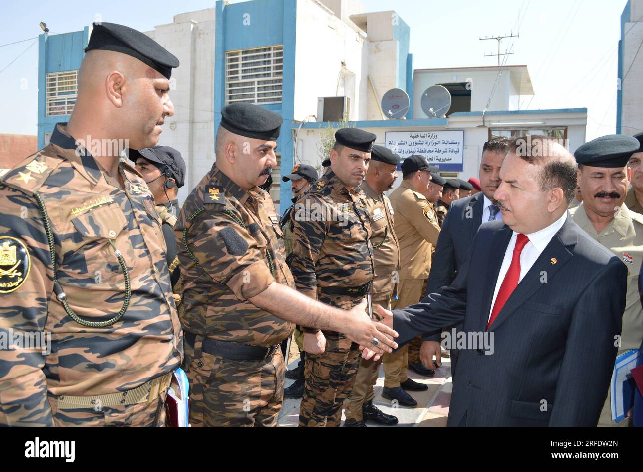 (190812) -- , Aug. 12, 2019 -- Iraqi Interior Minister Yassin al-Yasiri shakes hands with a police officers in Mosul, Iraq on Aug. 11, 2019. The Iraqi Interior Ministry reinstated more than 13,000 police personnel after being fired following the extremist Islamic State (IS) militants took control of Iraq s northern city of Mosul in 2014. IRAQ--POLICE PERSONNEL REINSTATING Baghdad PUBLICATIONxNOTxINxCHN Stock Photo