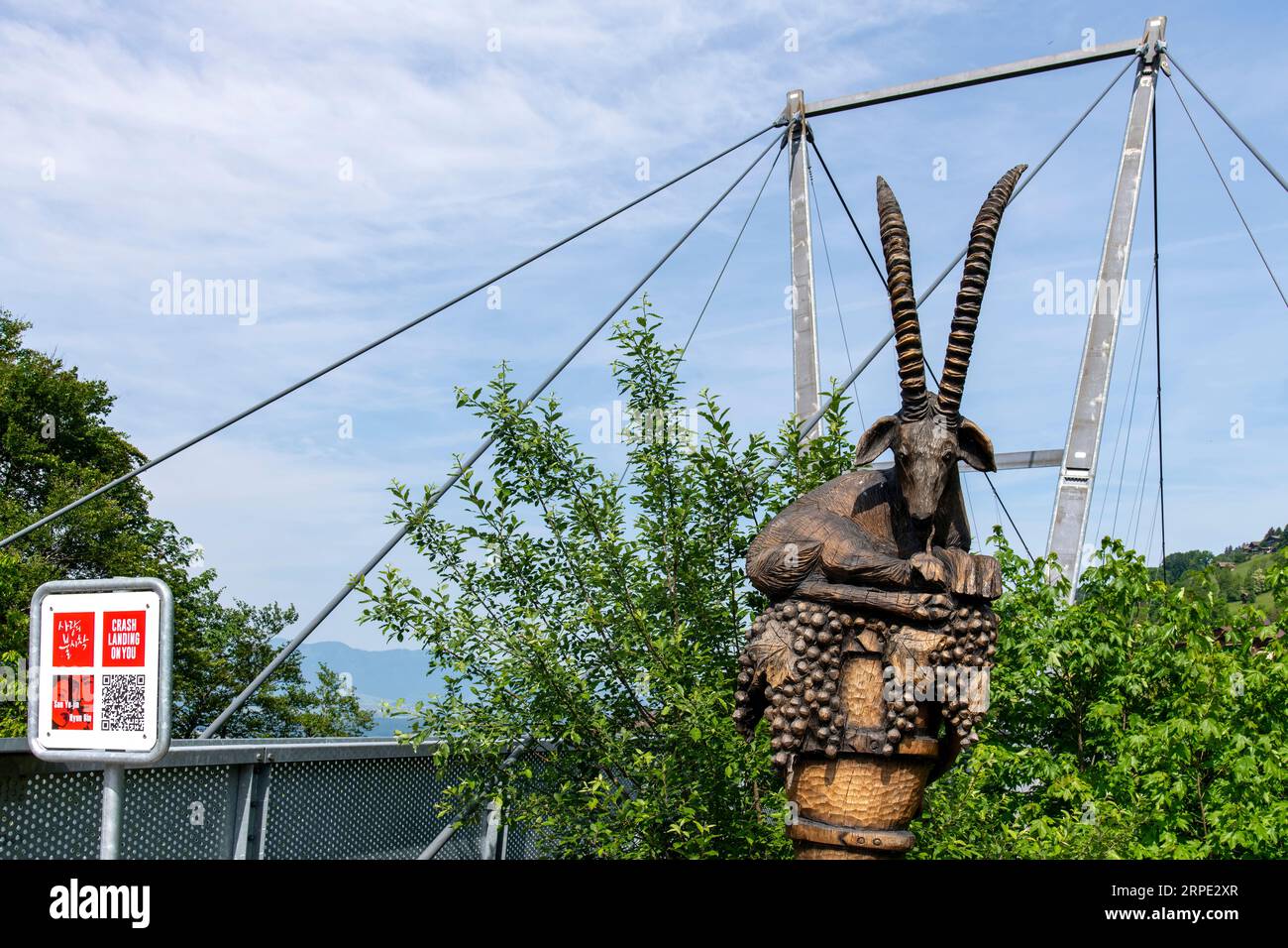 Sigriswil, Switzerland-May 30, 2023; Alpine Ibex (wild goat) wooden statue at entrance of Panorama pedestrian suspension bridge Sigriswil over a deep Stock Photo
