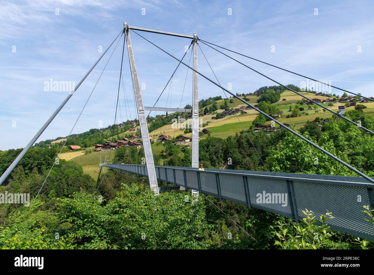 Sigriswil, Switzerland-May 30, 2023; Panorama pedestrian suspension bridge Sigriswil over a deep gorge with views of the Bernese Alps and Thunersee al Stock Photo