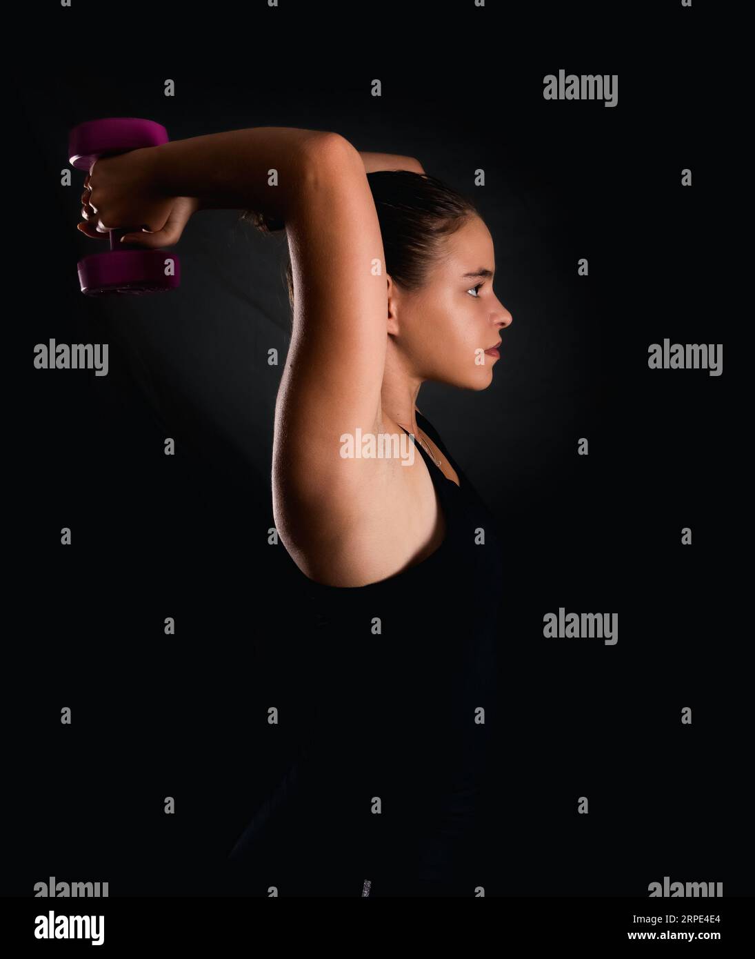 young woman training with pink barbells weight training for a healthy lifestyle and fitness . Stock Photo
