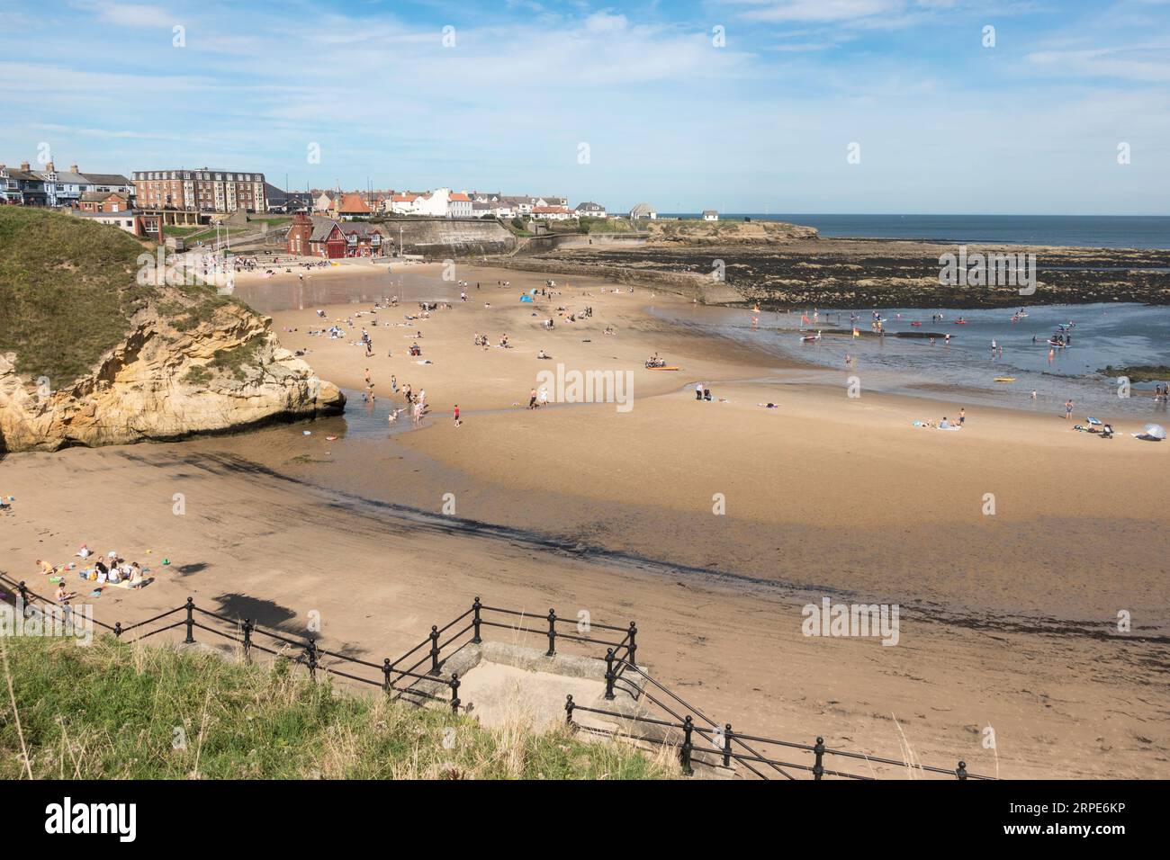Families enjoying the sunshine on the beach at Cullercoats Bay, England, UK Stock Photo