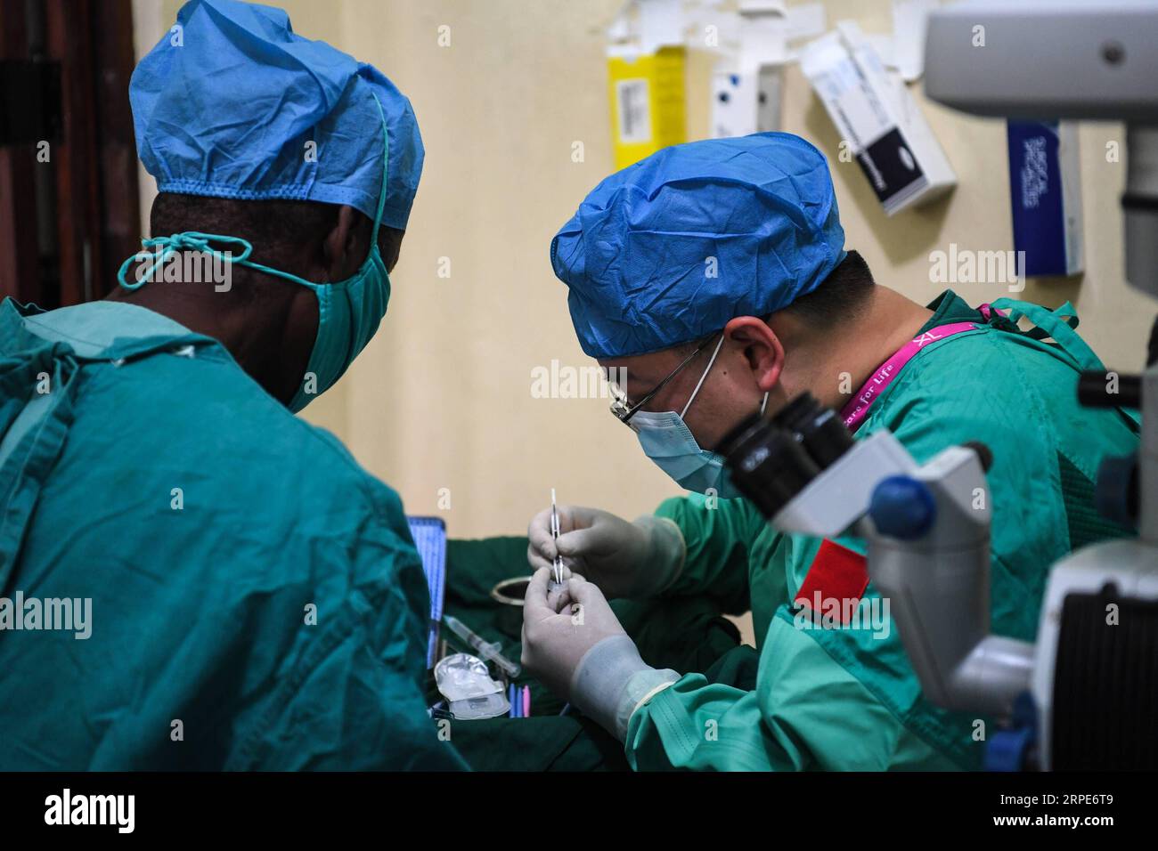 (190819) -- BEIJING, Aug. 19, 2019 -- Lin Xiaojun (R), a member of the 29th Chinese medical aid to Zanzibar, and a local doctor conduct a cataract surgery for Issa Khamis Issa in Zanzibar, Tanzania, Aug. 1, 2019. Since 1963, some 220 million patients in 48 African countries have been treated by Chinese medical personnel as of 2018, according to the National Health Commission. Currently, 983 Chinese doctors are providing free medical services in 45 African countries. ) AFRICA-CHINA-MEDICAL TEAMS-AID LixYan PUBLICATIONxNOTxINxCHN Stock Photo