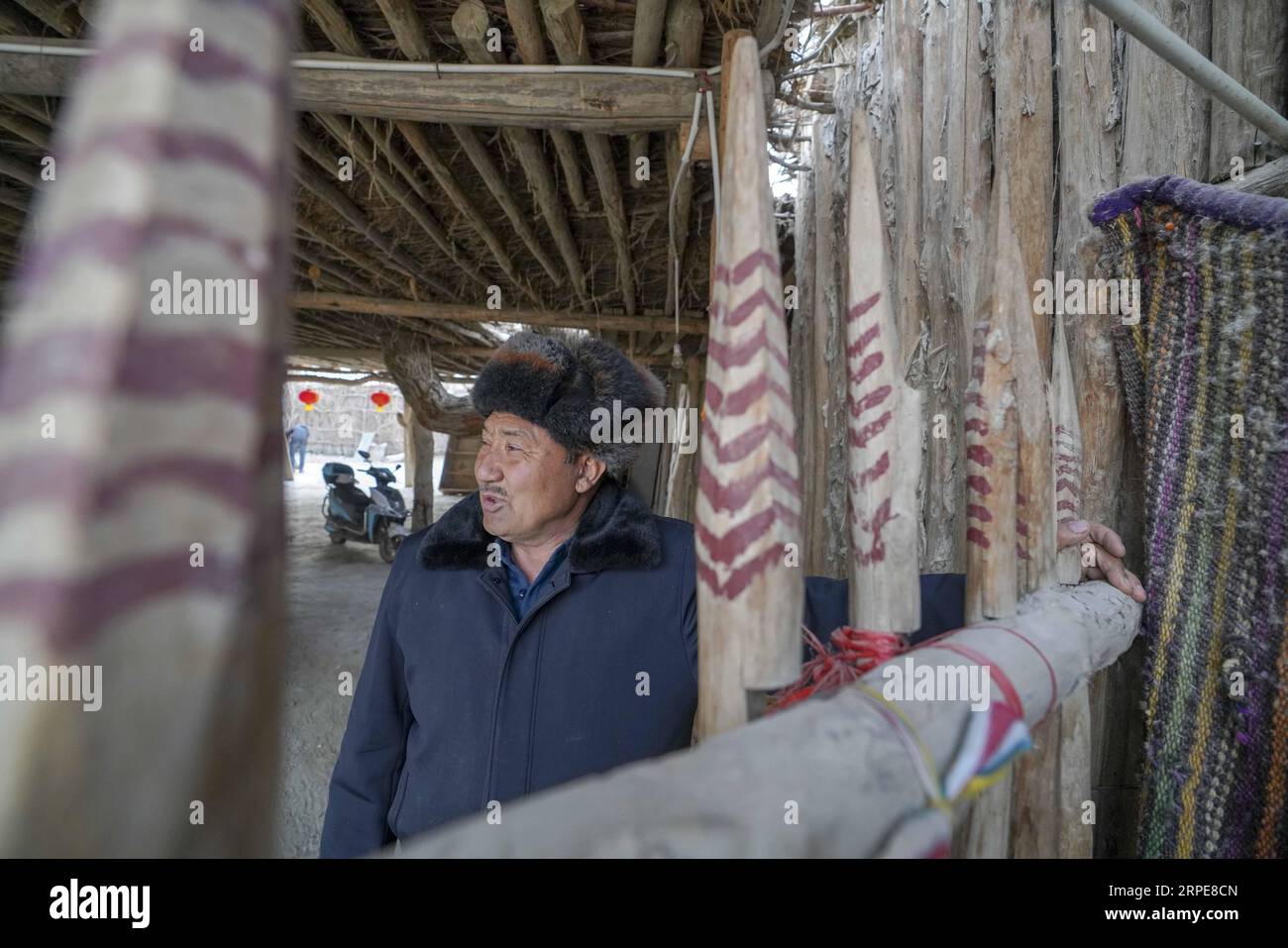 (190821) -- YULI, Aug. 21, 2019 -- Amudun Abudu is seen at home in Lop Nur People Village in Yuli County, northwest China s Xinjiang Uygur Autonomous Region, Jan. 29, 2019. Lop Nur People Village is located in Yuli County, where Tarim River flows through the deserts with populus euphratica forests reflection on the shimmering waves. Amudun Abudu, a 61-year old typical Lop Nur villager, works in local tourism industry. With the changes of the times, many Lop Nur people have various options for a living, yet he insists on the tradition of fishing in rivers and lakes. Not only does he make delici Stock Photo