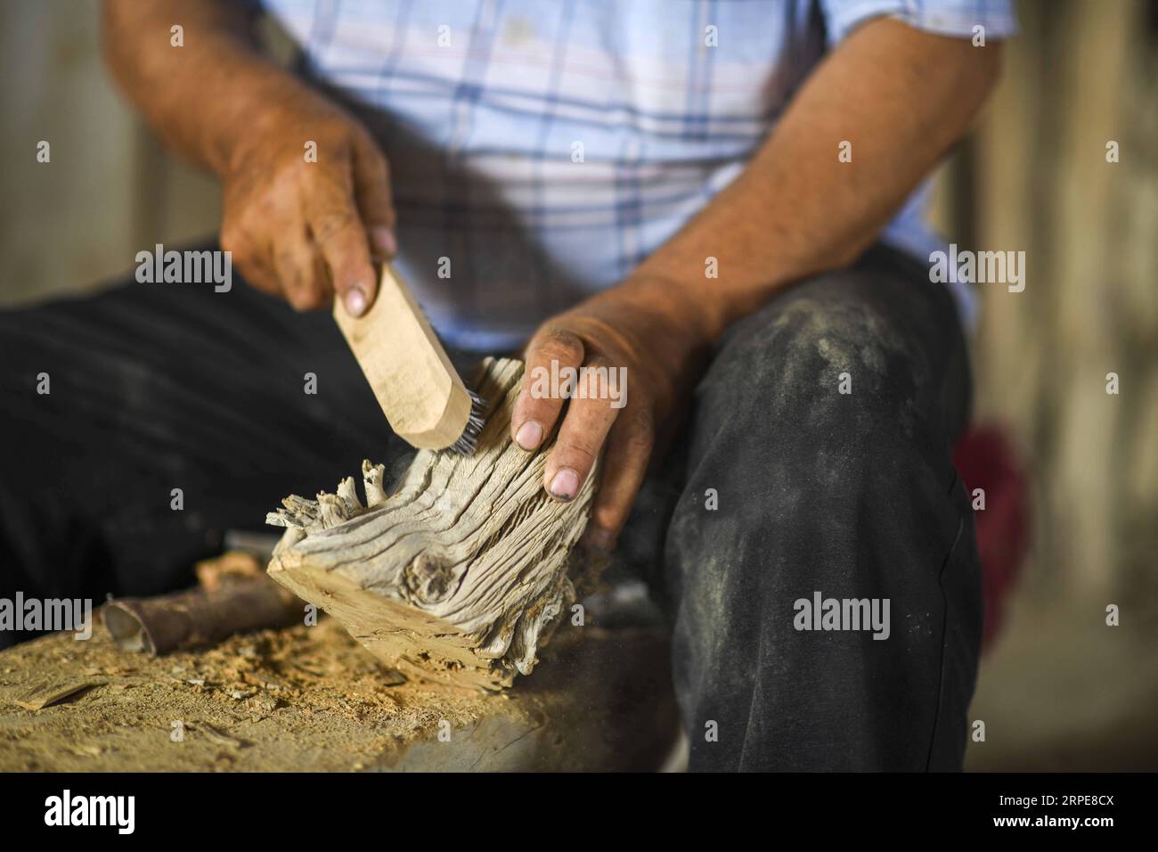 (190821) -- YULI, Aug. 21, 2019 -- Amudun Abudu makes a pen holder in Lop Nur People Village in Yuli County, northwest China s Xinjiang Uygur Autonomous Region, June 21, 2019. Lop Nur People Village is located in Yuli County, where Tarim River flows through the deserts with populus euphratica forests reflection on the shimmering waves. Amudun Abudu, a 61-year old typical Lop Nur villager, works in local tourism industry. With the changes of the times, many Lop Nur people have various options for a living, yet he insists on the tradition of fishing in rivers and lakes. Not only does he make del Stock Photo