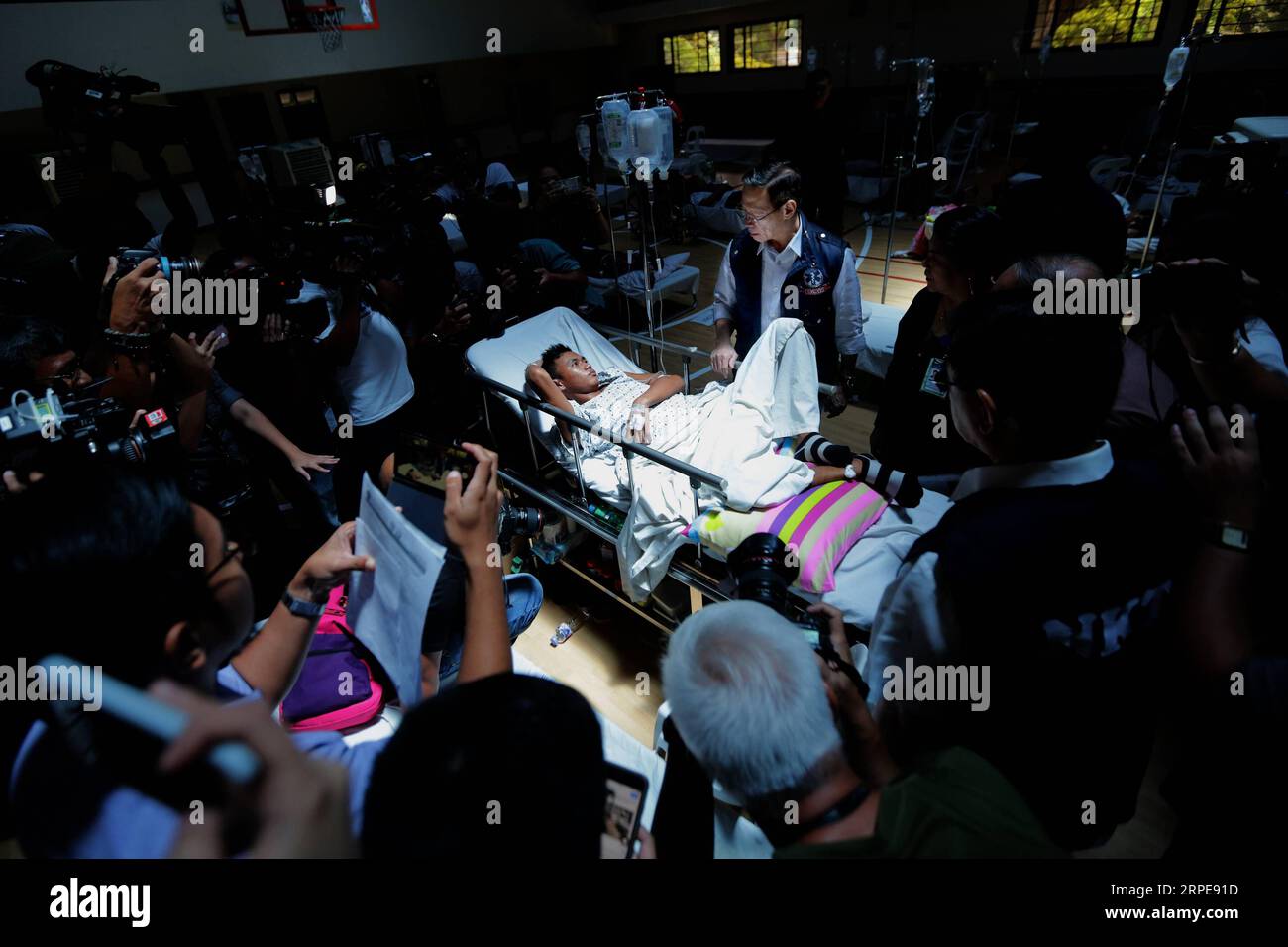 (190822) -- BEIJING, Aug. 22, 2019 -- Philippine Department of Health Secretary Francisco Duque III (C, standing) talks to a leptospirosis patient in a leptospirosis ward transformed from a covered basketball court in the National Kidney and Transplant Institute (NKTI) in Quezon City, the Philippines, Aug. 20, 2019. ) XINHUA PHOTOS OF THE DAY ROUELLExUMALI PUBLICATIONxNOTxINxCHN Stock Photo