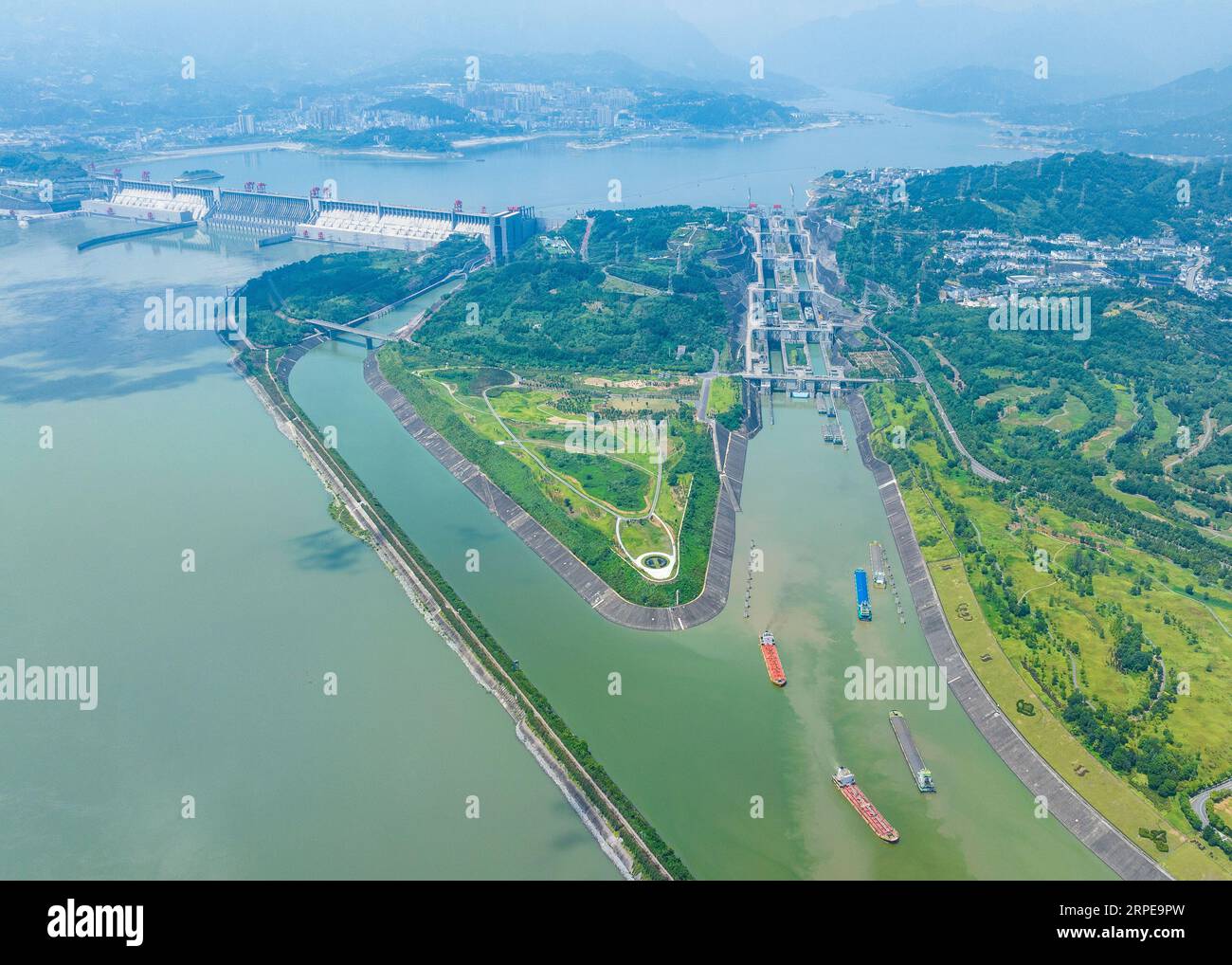 Zigui. 23rd Aug, 2023. This aerial photo taken on Aug. 23, 2023 shows ships passing through the five-tier ship locks of the Three Gorges Dam in Yichang, central China's Hubei Province. The monthly cargo throughput via the five-tier ship locks at the Three Gorges Dam, the world's largest hydropower project in the upper stream of the Yangtze, reached a record high of over 15.71 million tonnes in August, according to the China Three Gorges Corporation. Credit: Zheng Jiayu/Xinhua/Alamy Live News Stock Photo