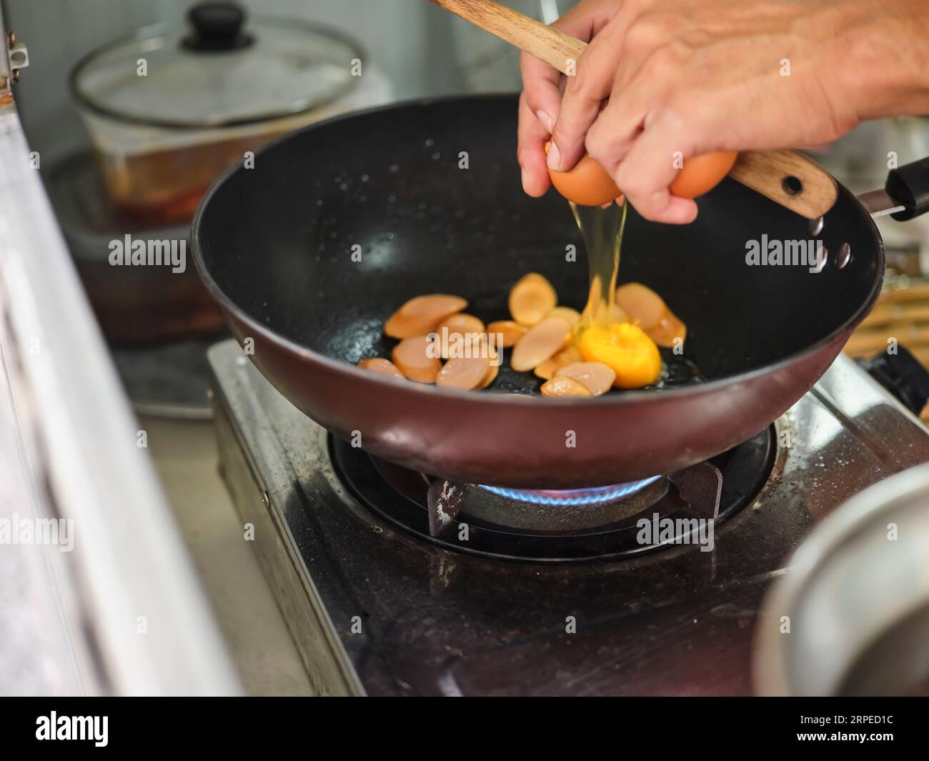 Cooking of sausage fried rice and crack an egg with mixed vegetable ...
