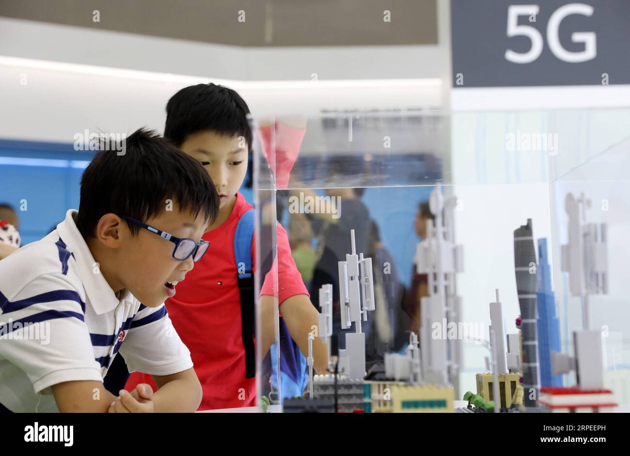 (190827) -- SHANGHAI, Aug. 27, 2019 -- Kids view a model of 5G base station at the Huawei 5G Experience Booth during the preview of the 2019 World Artificial Intelligence Conference in east China s Shanghai, Aug. 26, 2019. China s economic hub Shanghai will hold the 2019 World Artificial Intelligence Conference (WAIC) from August 29 to 31. This year s event will focus on a connected intelligent world enabled by the development of AI technologies, according to the Shanghai municipal government. There will be two summit forums, where governors, representatives from international organizations, l Stock Photo