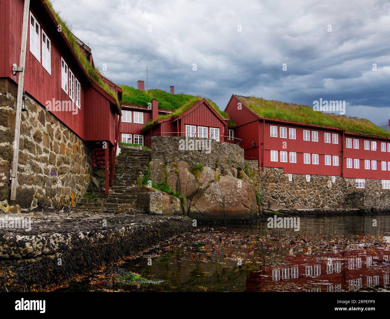 Typical for the Faroe Islands are the green roofs of the houses Stock Photo