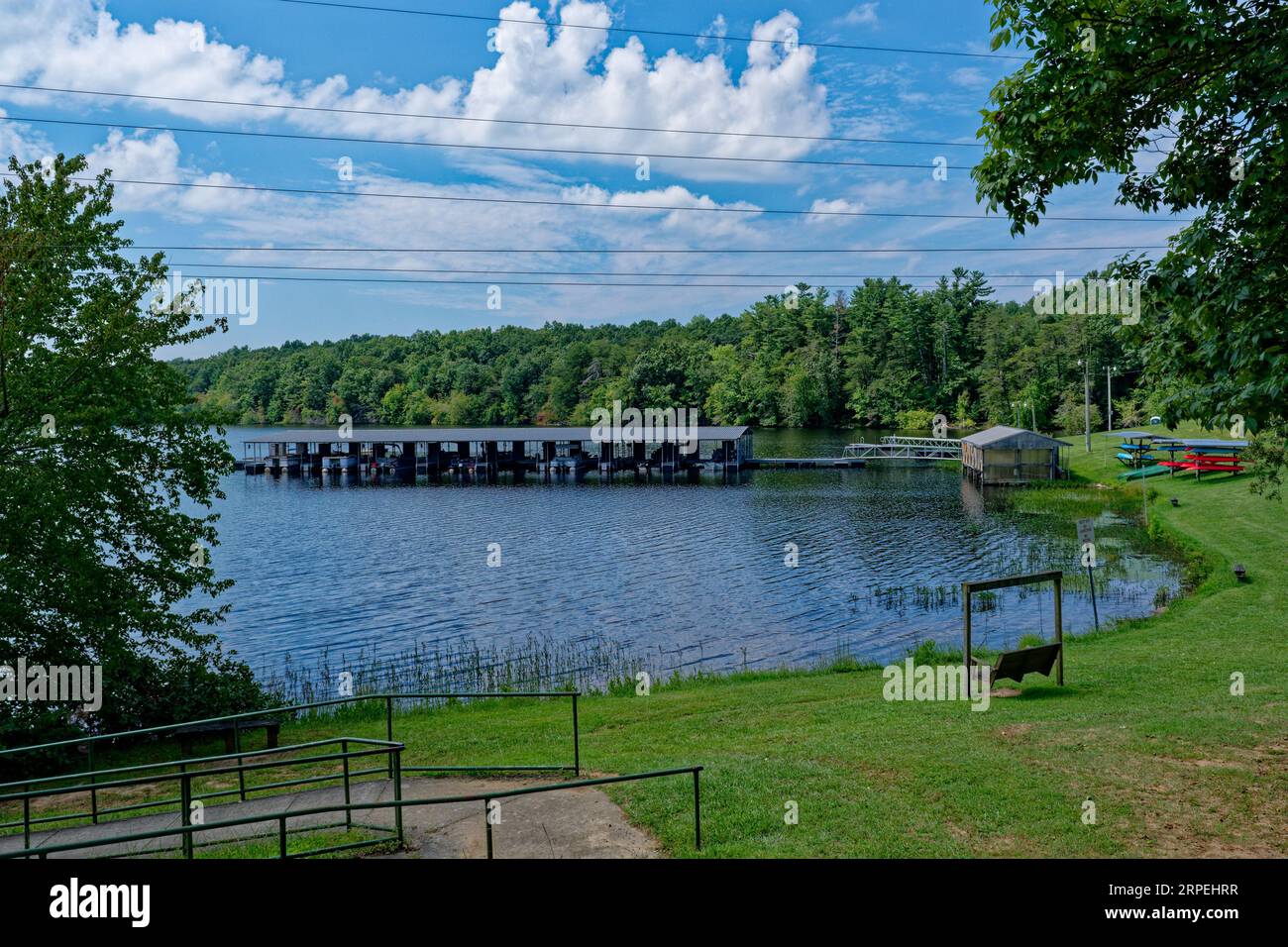 A marina and park with pontoons boats canoes and kayaks and benches to sit by the water on a sunny day in summertime in Tennessee Stock Photo