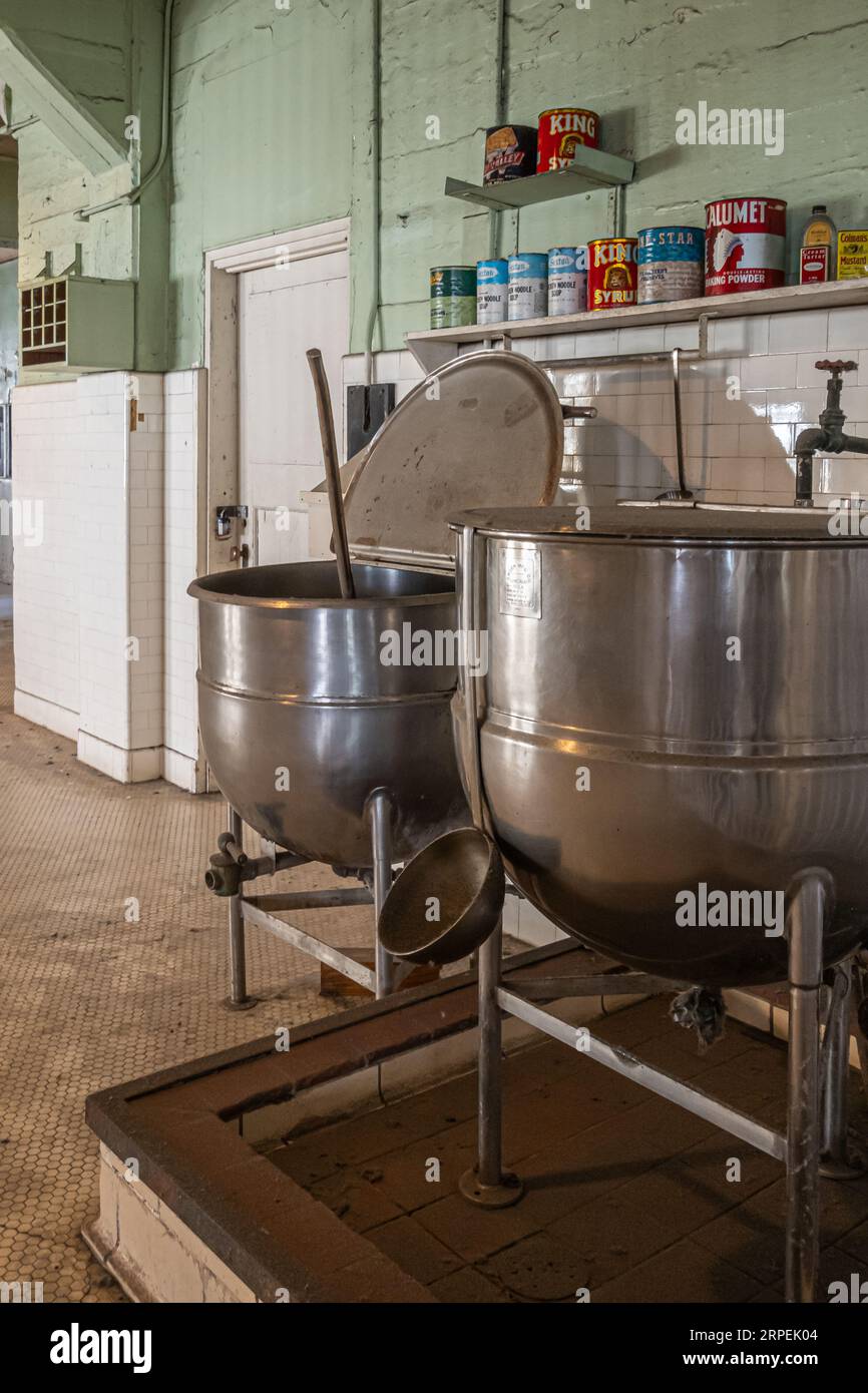 San Francisco, CA, USA - July 12, 2023: Inside historic Alcatraz prison. Large kitchen cooking vessels and line of historic cooking ingredient pots Stock Photo