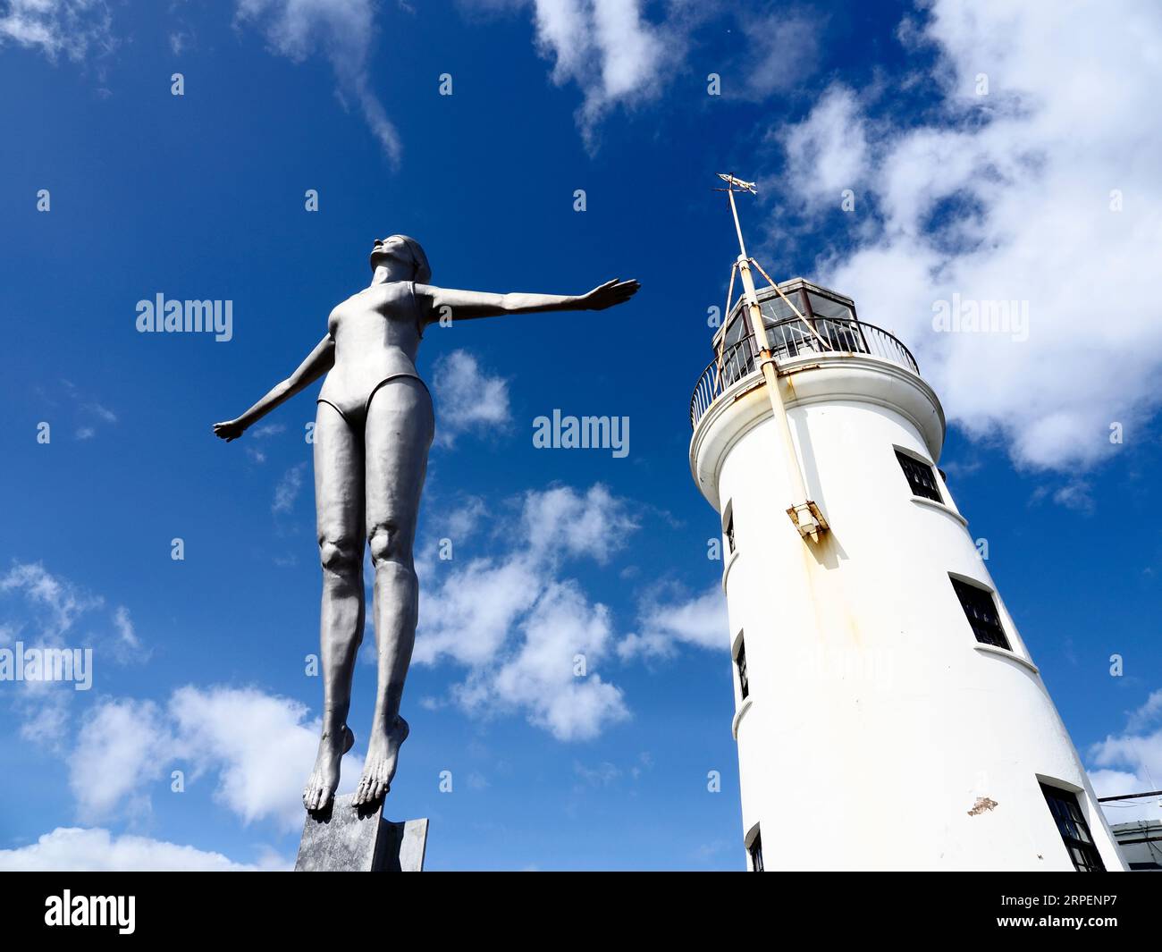 Lighthouse and Diving Belle Statue by artist Craig Knowles at the harbour Scarborough North Yorkshire England Stock Photo