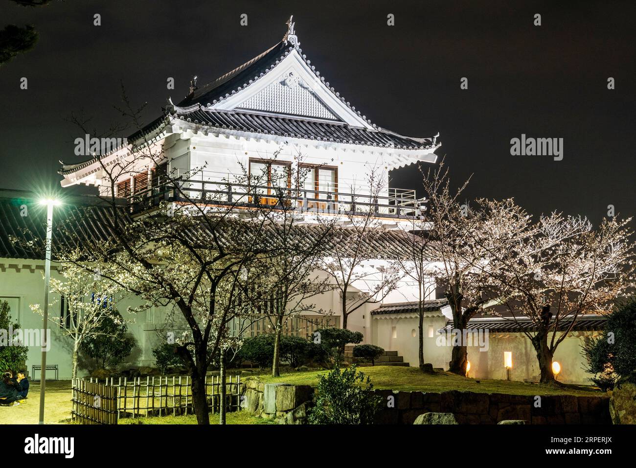 Night view of the illuminated Tsukimi yagura, turret, with cherry blossoms at Fukuyama castle in Japan. It has a balcony, which used for moon viewing. Stock Photo