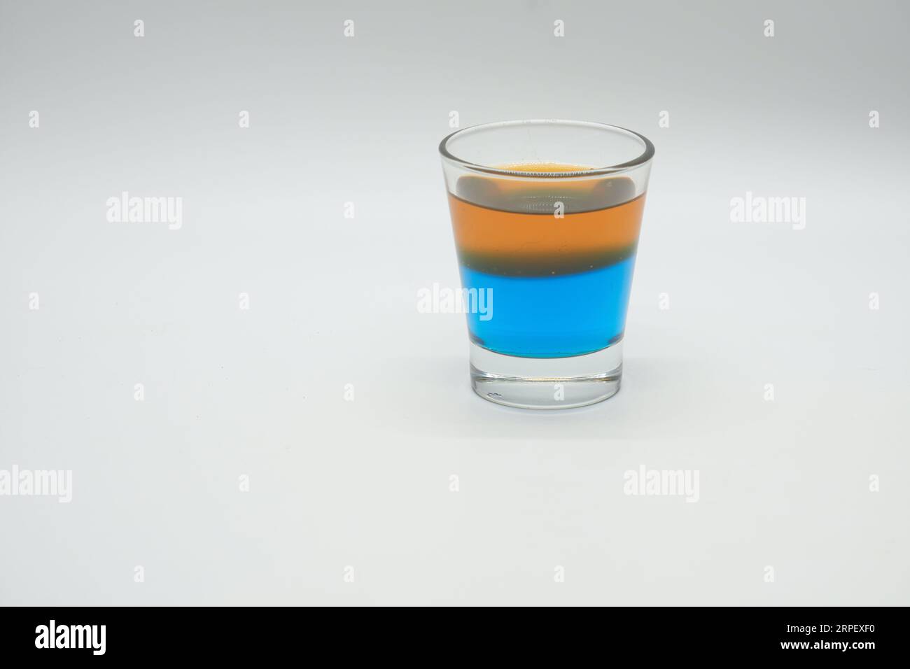 Layers of Blue Berry Jelly and Orange Jelly in a shot glass Stock Photo