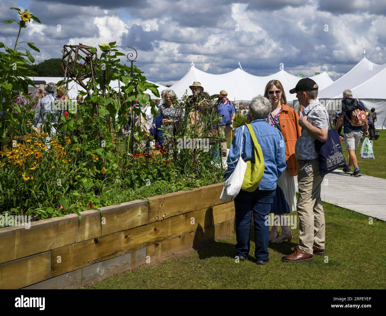 Visitors view colourful garden flowers horticultural raised bed