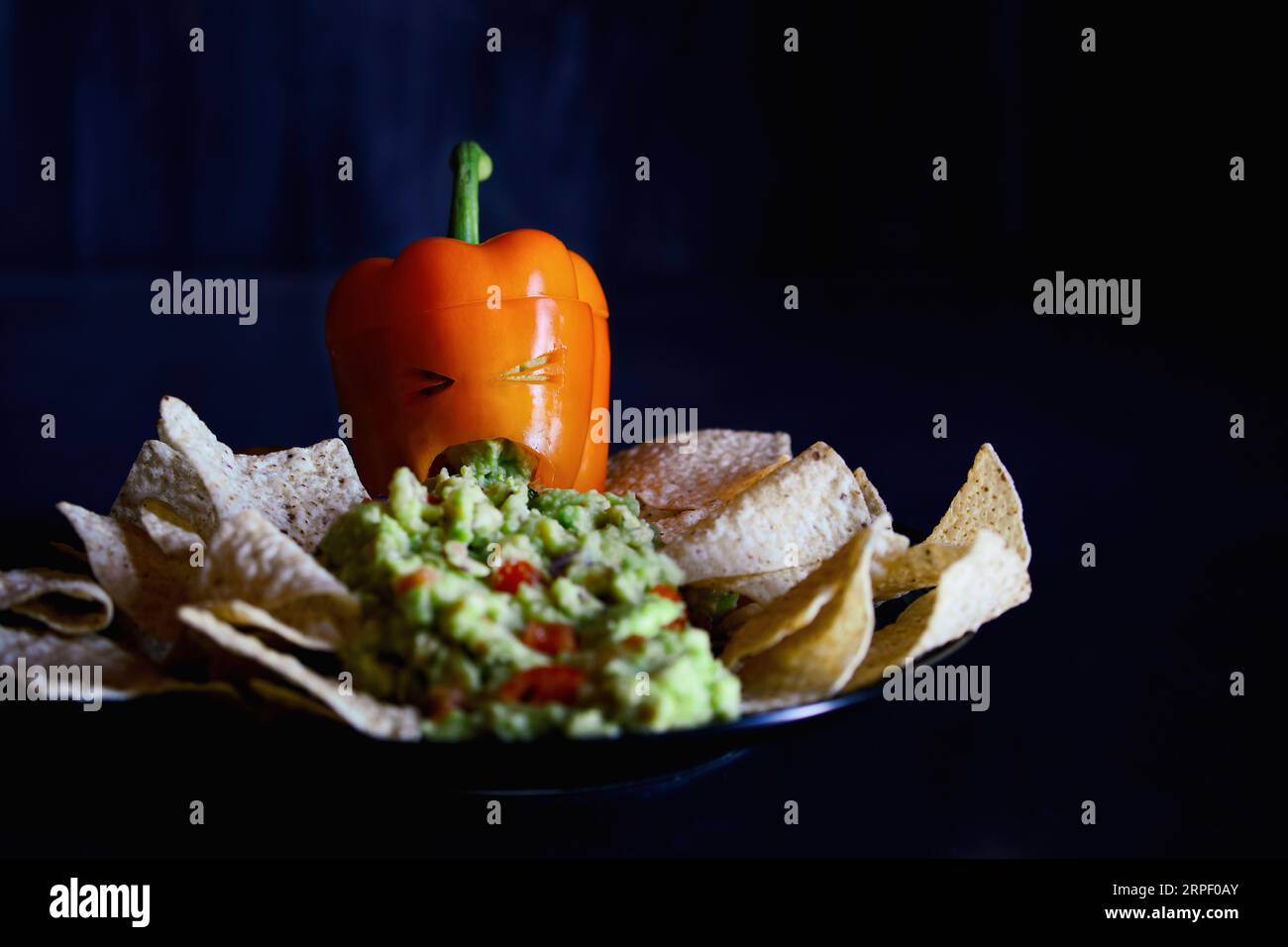 Stuffed sweet orange bell pepper as monster with cut out face carved