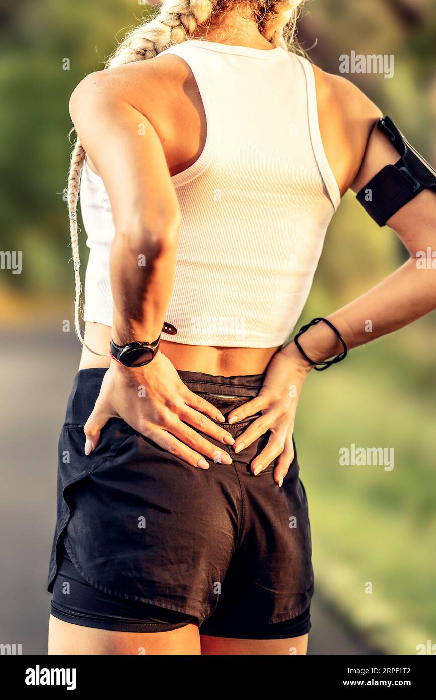 Young woman with an athletic figure and a lower back injury. Back pain