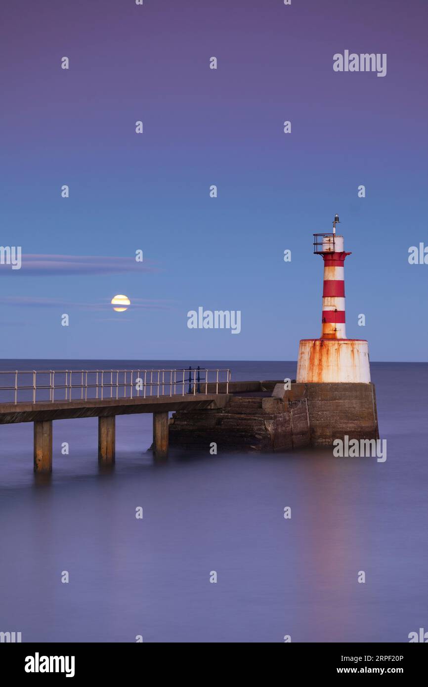 Long exposure image of the south Jetty and lighthouse at Amble with rising Moon Photographed in autumn/winter (November), Amble, Northumberland, North Stock Photo