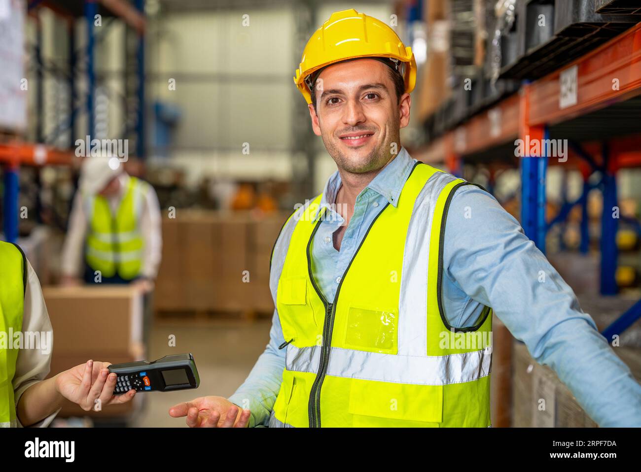 Warehouse workers talking together checking goods in storage Stock Photo