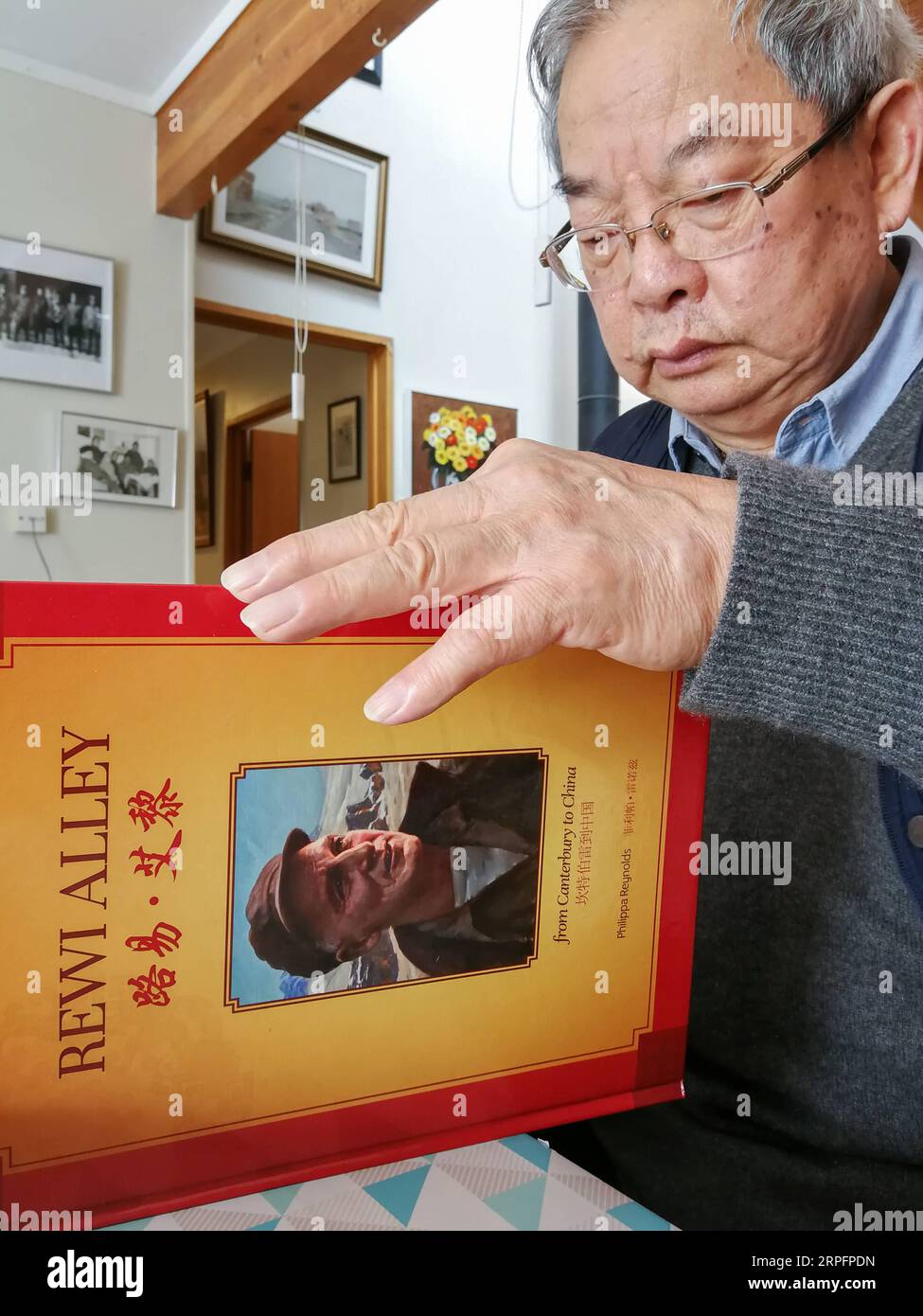 190929 -- WELLINGTON, Sept. 29, 2019 -- Deng Bangzhen, a painter and one of Rewi Alley s adopted sons, reads books about Rewi Alley in Auckland, New Zealand, Aug. 30, 2019. People from both New Zealand and China still very often talk about Rewi Alley, a New Zealand-born writer, social reformer and educator, even 32 years after his death in Beijing. An old friend of the Chinese people, Rewi Alley spent 60 years living and working in China. He made important contributions to the Chinese people s fight against the fascist invasion, the economic development of the new China, and the friendship bet Stock Photo