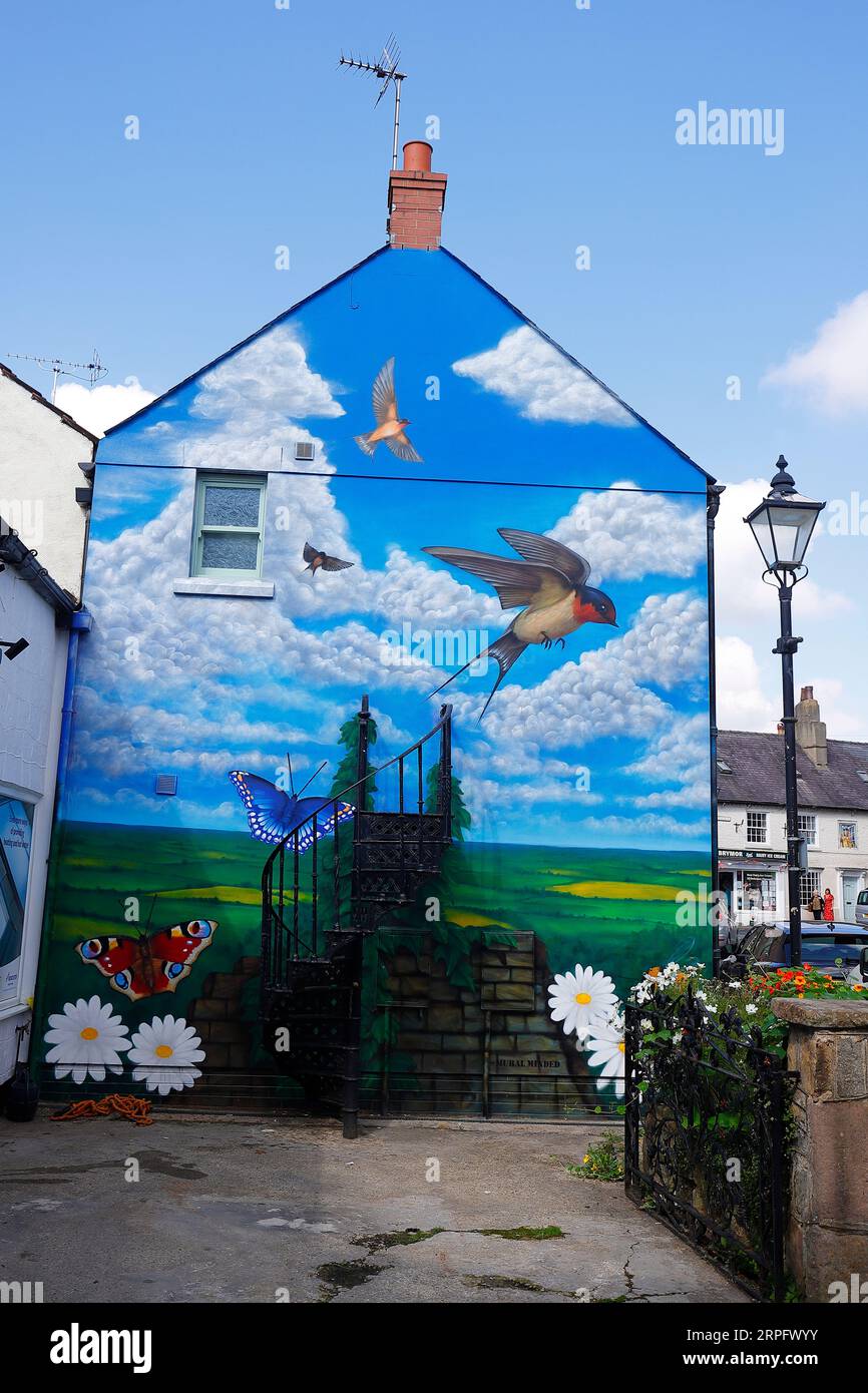 A gable end mural on Cheapside in Knarwborough,North Yorkshire by artist Sam Porter depicting flying swallows in a rural setting Stock Photo