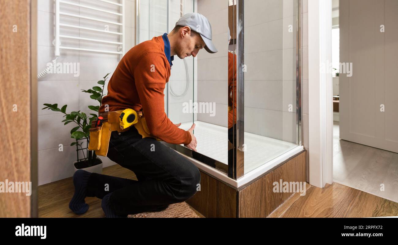 Professional handyman working in shower booth indoors Stock Photo Alamy