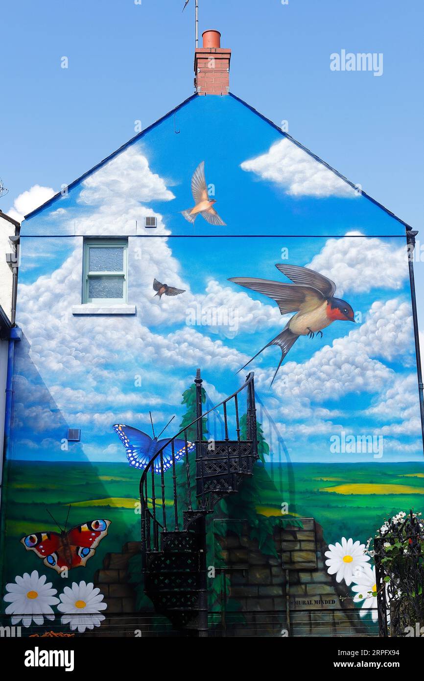 A gable end mural on Cheapside in Knarwborough,North Yorkshire by artist Sam Porter depicting flying swallows in a rural setting Stock Photo