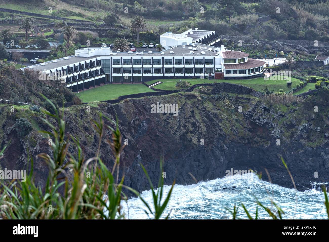 The ANC Experience Resort overlooking rough seas along the rocky coastline on the Azorean Island of Caloura, Sao Miguel, Portugal. Stock Photo