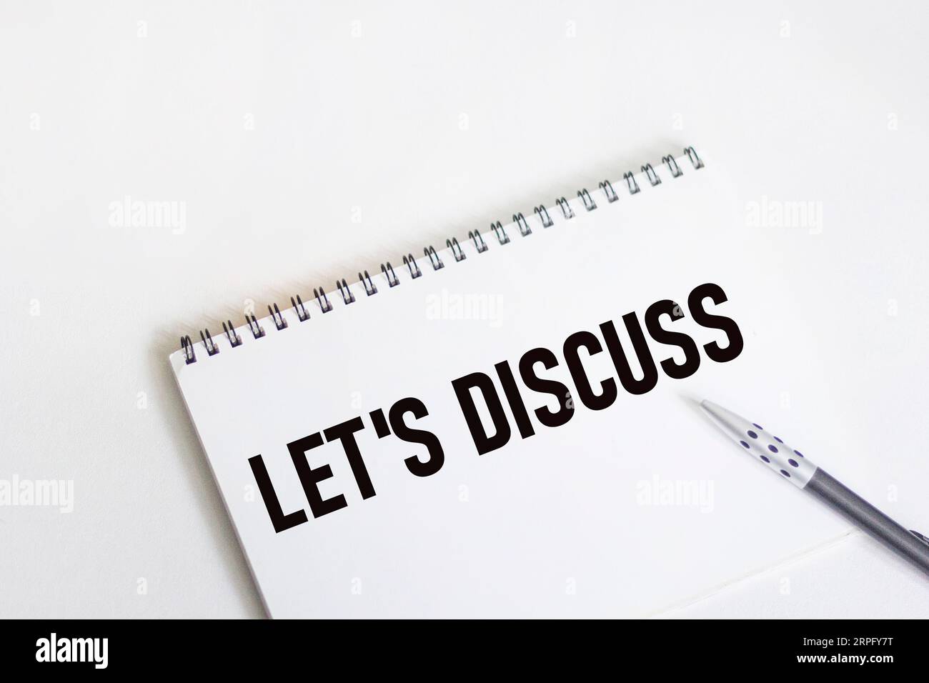Let's discuss text on notepad, isolated on white background Stock Photo