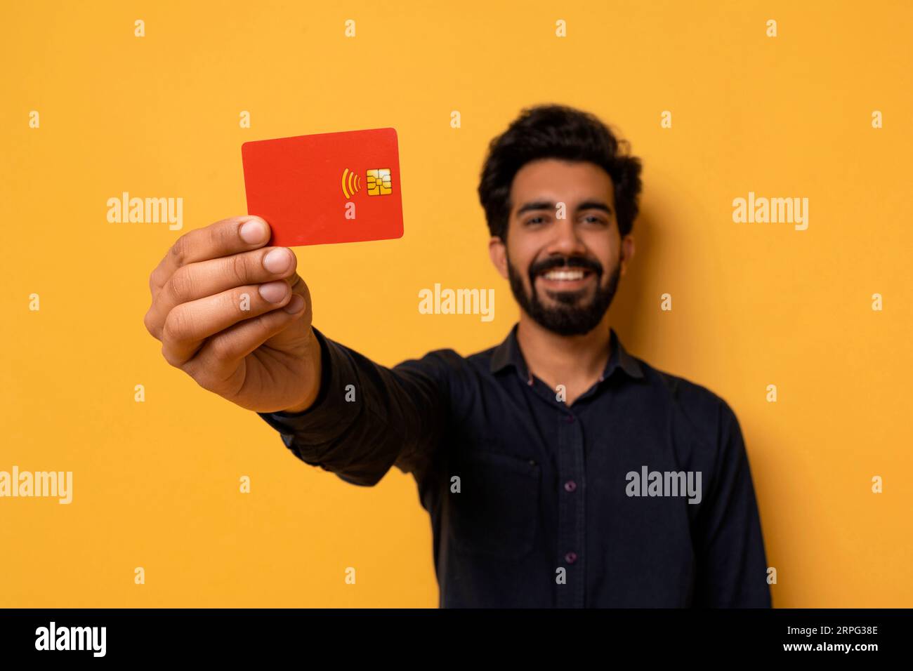 Smiling Young Indian Man Showing Credit Card At Camera Stock Photo