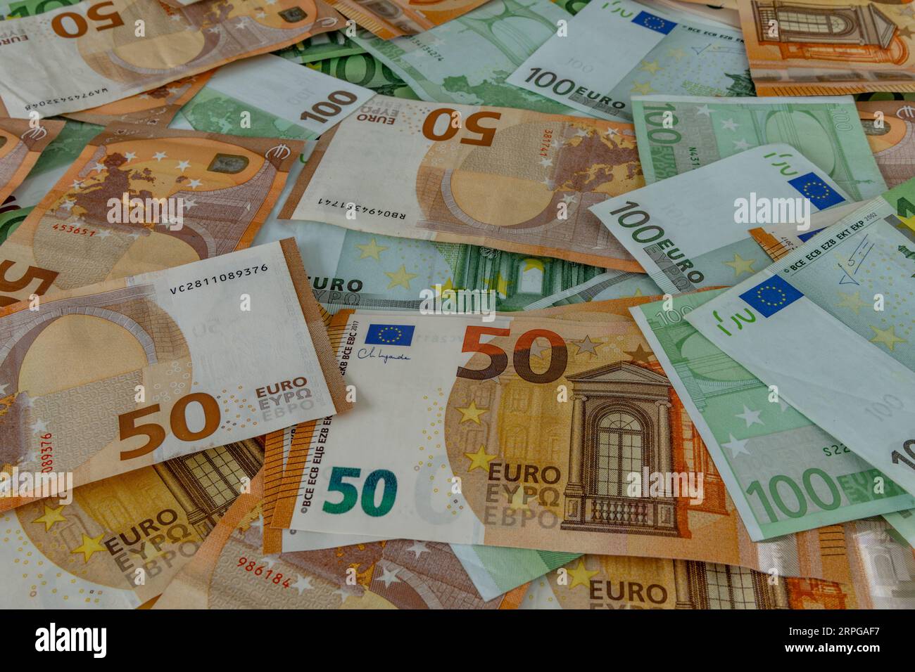 Money scattered on the table one hundred and two hundred Euro banknotes Stock Photo