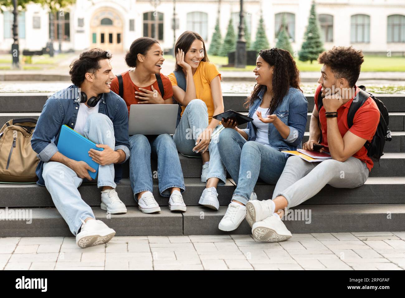 Group Of Multiethnic Students Chatting And Having Fun After Classes Stock Photo