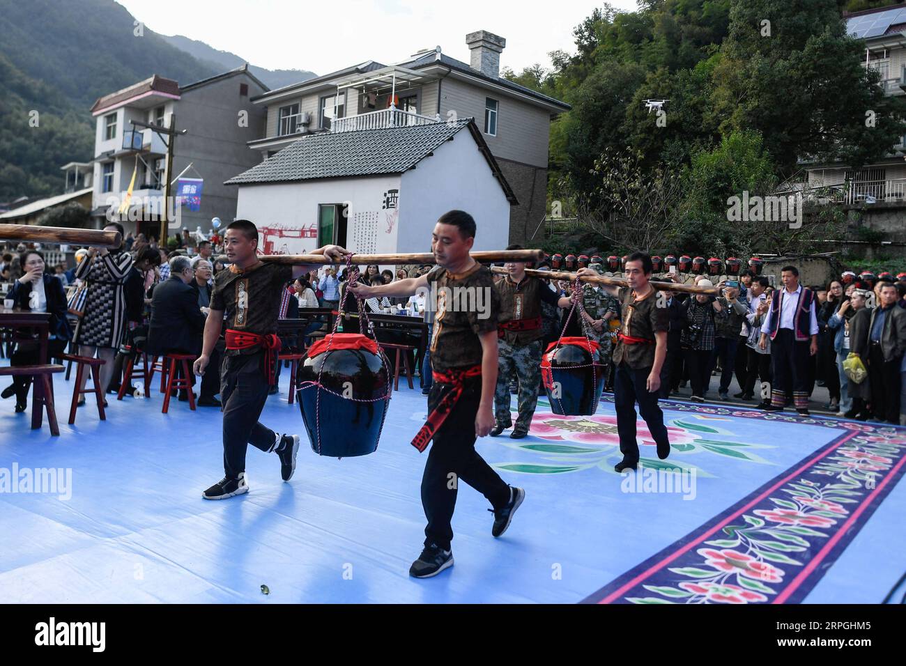 191016 -- HANGZHOU, Oct. 16, 2019 -- Local villagers carry jars of wine during the long-table banquet held at Longfeng ethnic village in Eshan Township of the She ethnic group of Tonglu County, east China s Zhejiang Province, Oct. 16, 2019. More than 90 tables of delicacies were presented at the long-table banquet, attracting local villagers as well as tourists to enjoy the food of the She ethnic group.  CHINA-ZHEJIANG-ESHAN-LONG-TABLE BANQUET CN HuangxZongzhi PUBLICATIONxNOTxINxCHN Stock Photo