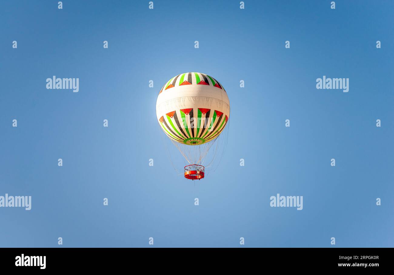 Isolated balloon with the colors of the Jordanian flag in cloudless blue sky. Stock Photo