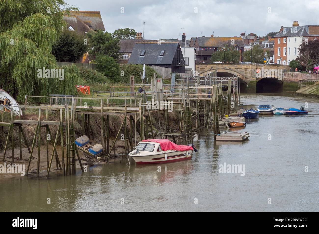 With the tide out, boats lie low on their mooring on the River Arun in Arundel, West Sussex, UK. Stock Photo