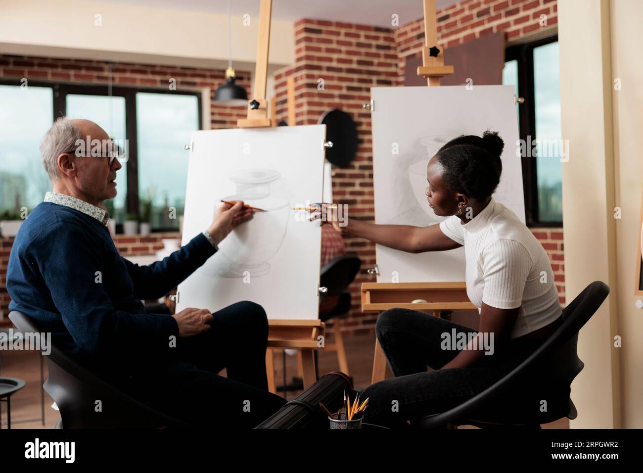 Diverse students discuss sketching techniques during drawing lesson