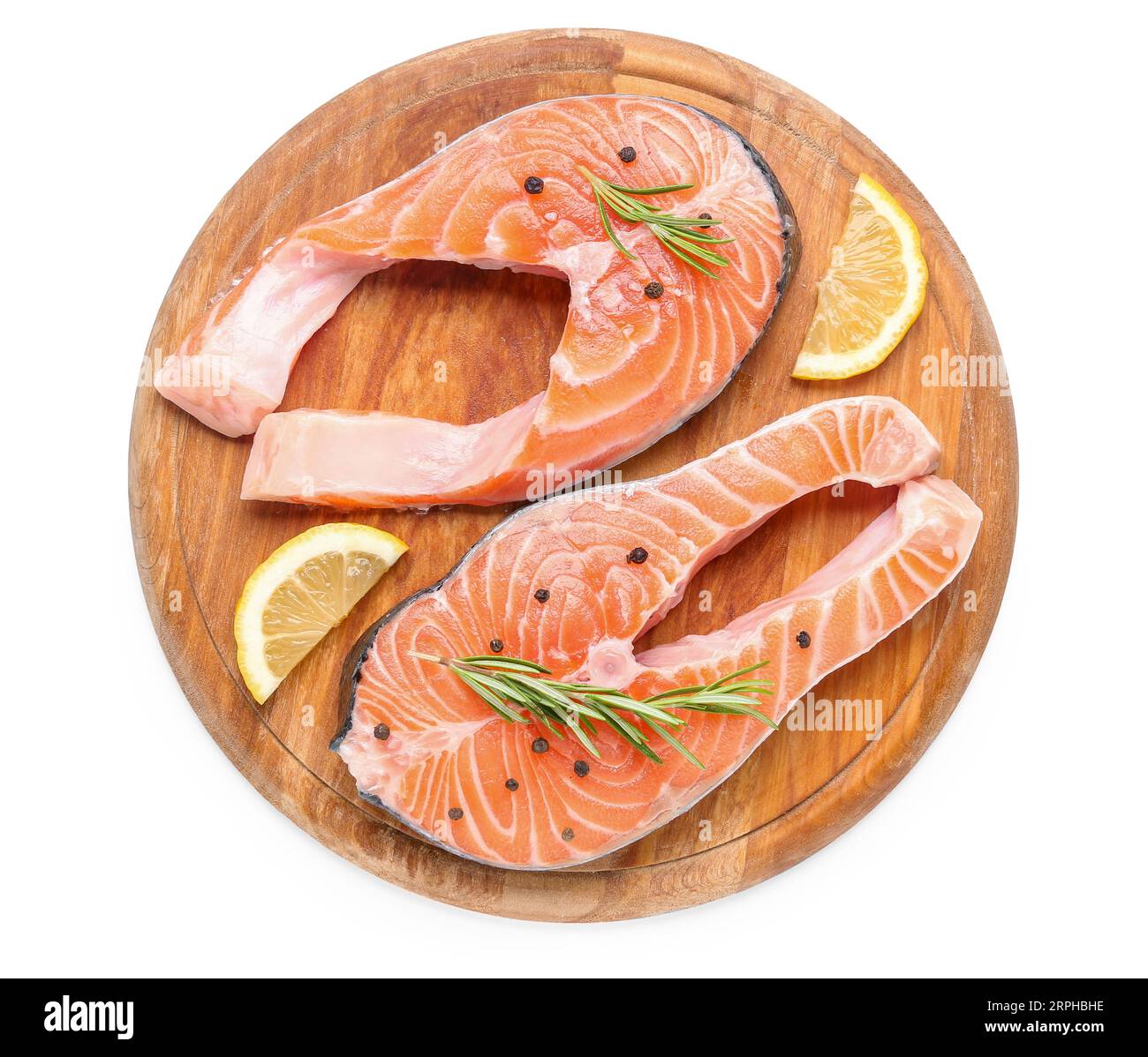 Wooden board with raw salmon steaks and different spices on white ...