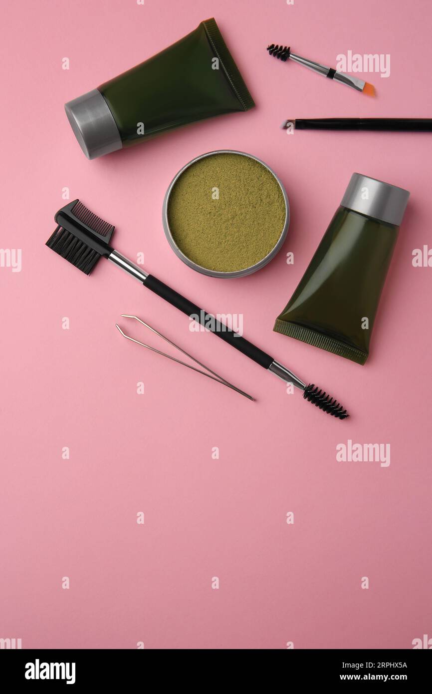 Flat lay composition with eyebrow henna and tools on pink background. Space for text Stock Photo