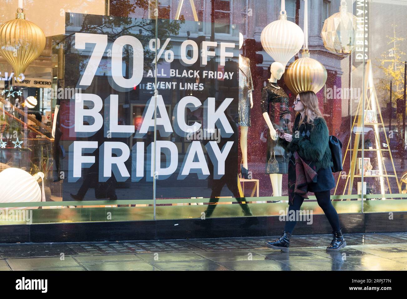 191129 -- LONDON, Nov. 29, 2019 Xinhua -- A woman walks past a shop window advertising Black Friday sales in London, Britain on Nov. 29, 2019. Photo by Ray Tang/Xinhua BRITAIN-LONDON-BLACK FRIDAY-SALES PUBLICATIONxNOTxINxCHN Stock Photo