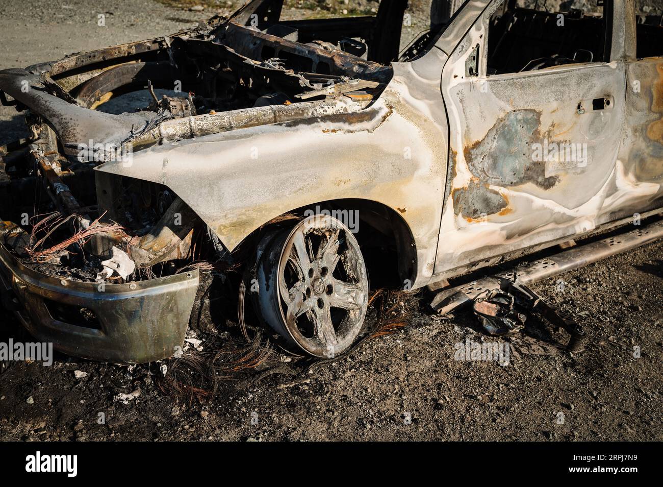 A burned out Dodge pick up truck lies abandoned beside a gravel road in rural British Columbia, Canada. Stock Photo