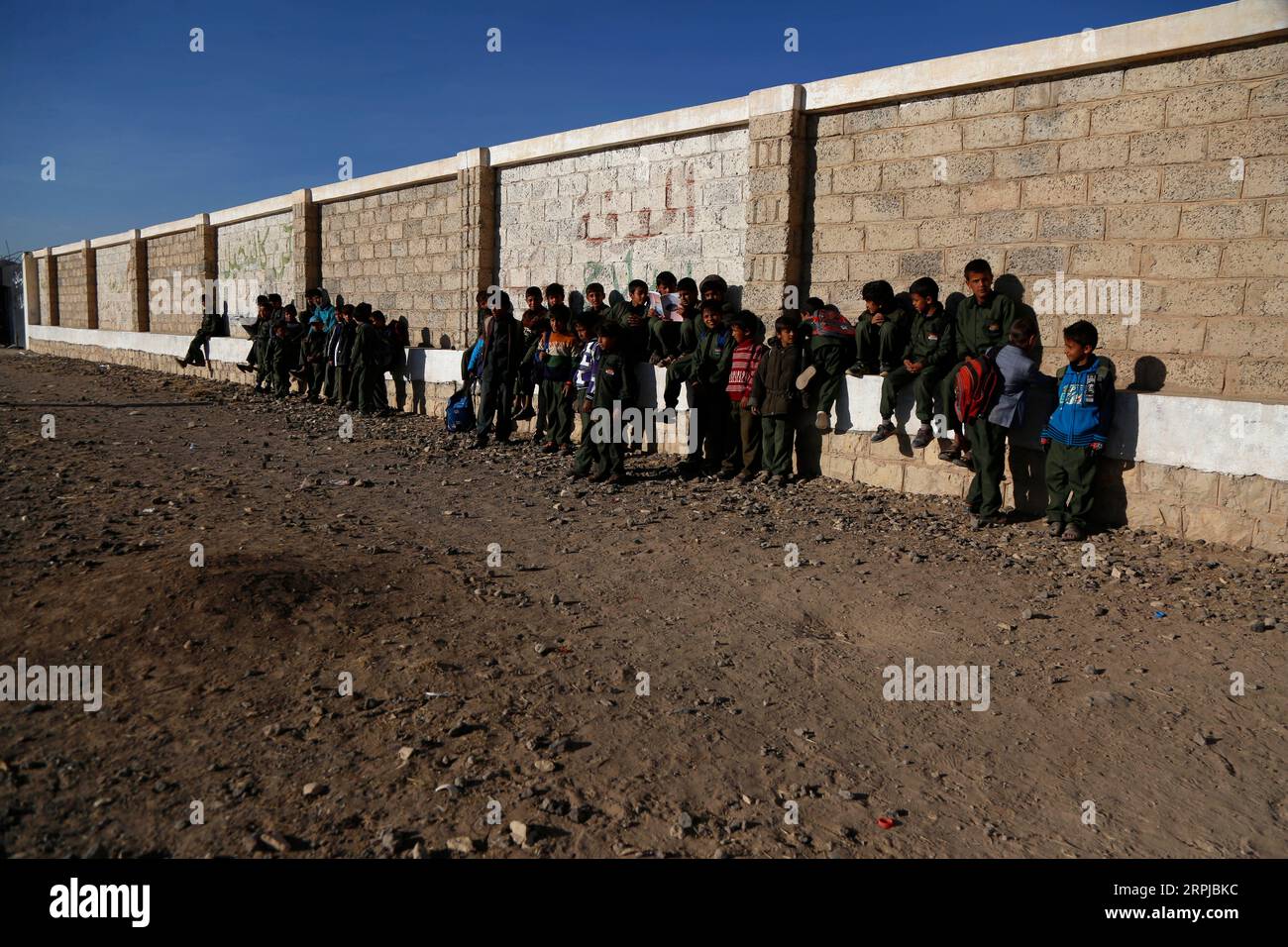 191204 -- SANAA, Dec. 4, 2019 -- Students gather beside the wall at the Yahya Mathkour School in Al-Rahabah area on the northern outskirts of Sanaa, Yemen, on Dec. 3, 2019. During the nearly five years of civil war which has destroyed Yemen s education system, 2 million school-aged children in the country were forced out of school, while 3.7 million others are facing this risk because of the non-payment of teachers salaries, according to the UNICEF. TO GO WITH Feature: Yemeni pupils take classes outside crumbling school building amid bitter winter Photo by Mohammed Mohammed/Xinhua YEMEN-SANAA- Stock Photo