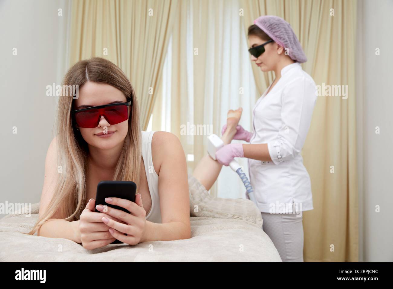 Laser hair removal for legs: young woman reclines at a reputable beauty salon Stock Photo