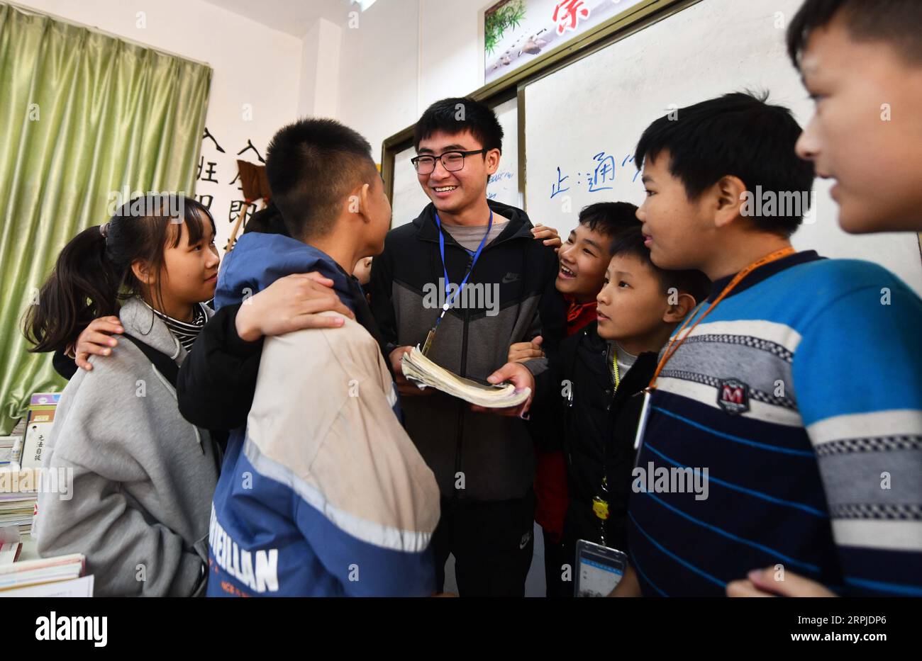 191206 -- RONGSHUI, Dec. 6, 2019 -- Xu Chenxi 3rd L, a postgraduate student of Northwestern Polytechnical University NPU who volunteers here as a head teacher, talks with students during class break at Siyuan Experimental School in Rongshui Miao Autonomous County, south China s Guangxi Zhuang Autonomous Region, Dec. 5, 2019. Rongshui is among the 20 deeply impoverished counties in south China s Guangxi. Off its 115 poor villages, 73 are deeply impoverished. Since 2015, the NPU has launched educational assistance to the county where education level is low. Relying on its S&T as well as educatio Stock Photo